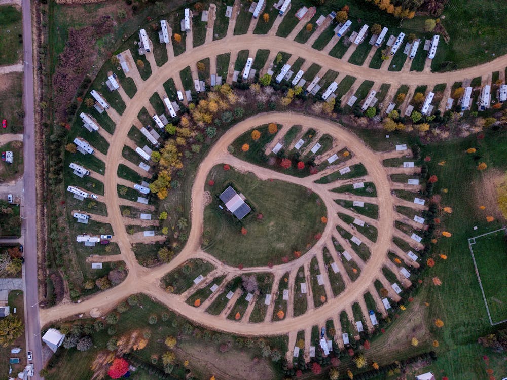 Aerial view of a private RV park with rows of motorhomes on full-hookup sites